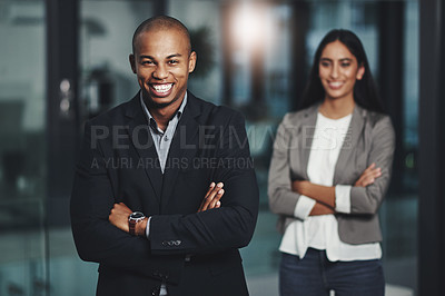 Buy stock photo Portrait of a young businessman standing in an office with his colleague in  the background