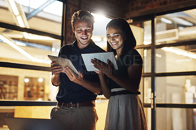 Buy stock photo Cropped shot of two young designer using their digital tablets while working late in the office