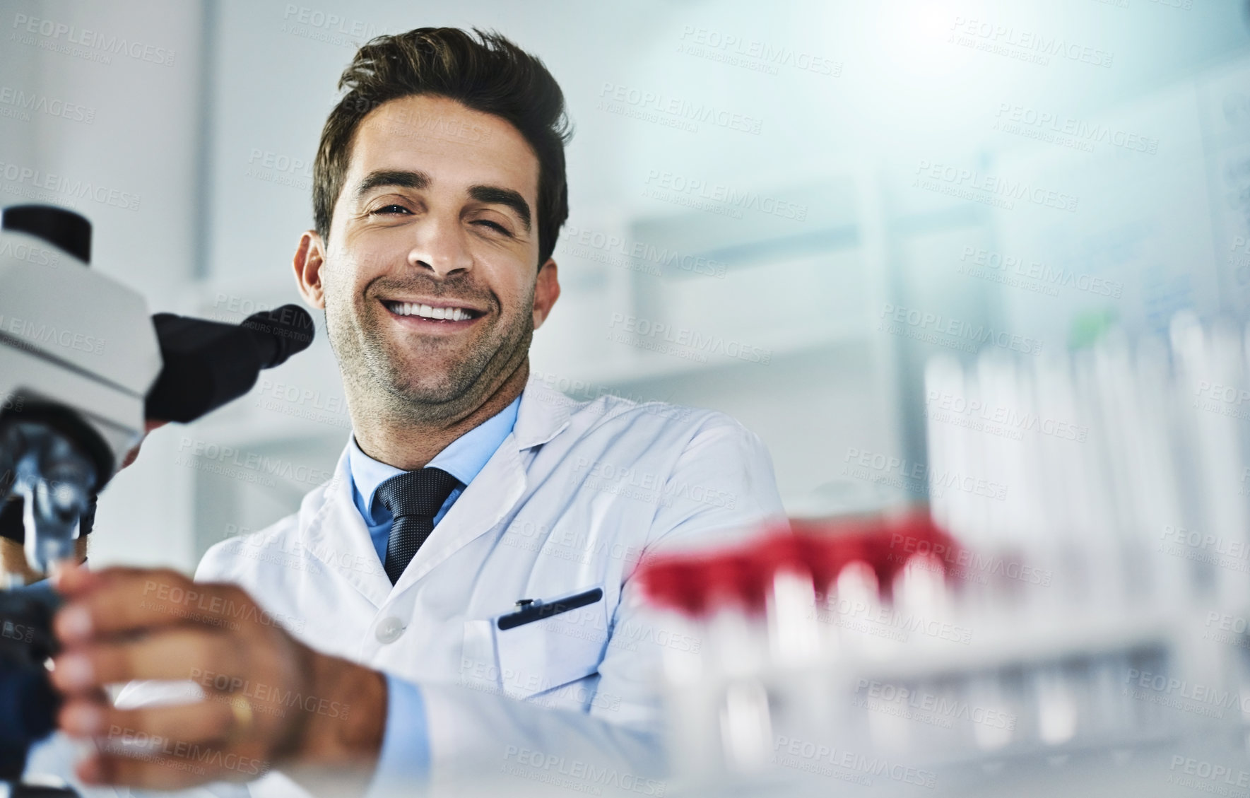Buy stock photo Portrait of a scientist using a microscope in a lab
