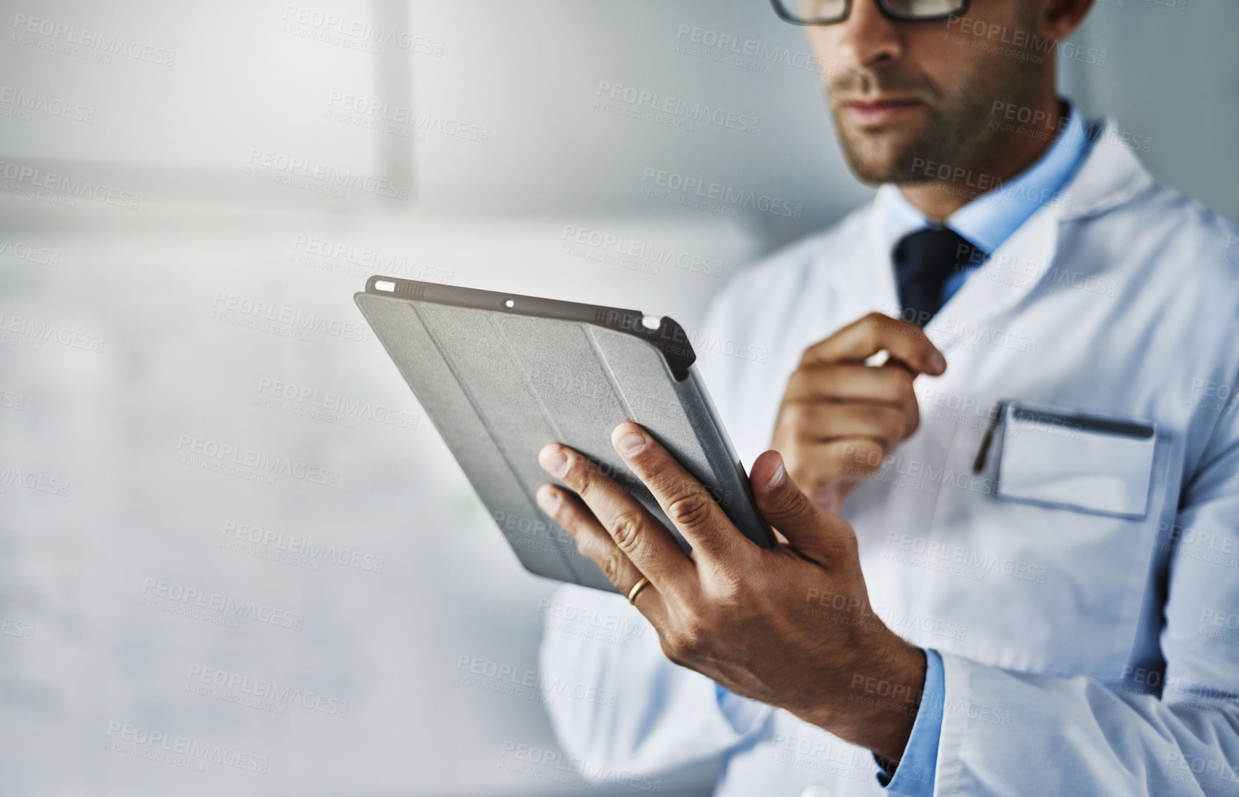 Buy stock photo Closeup shot of an unrecognizable doctor working on a digital tablet