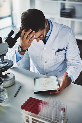 Buy stock photo Shot of a scientist looking stressed out while working in a lab