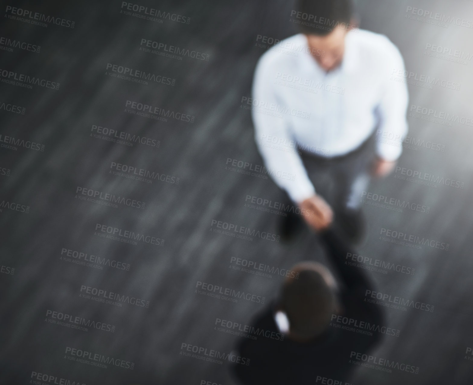 Buy stock photo Defocused shot of two businessmen shaking hands in an office