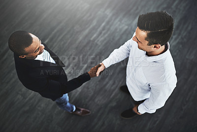 Buy stock photo High angle shot of two businessmen shaking hands in an office