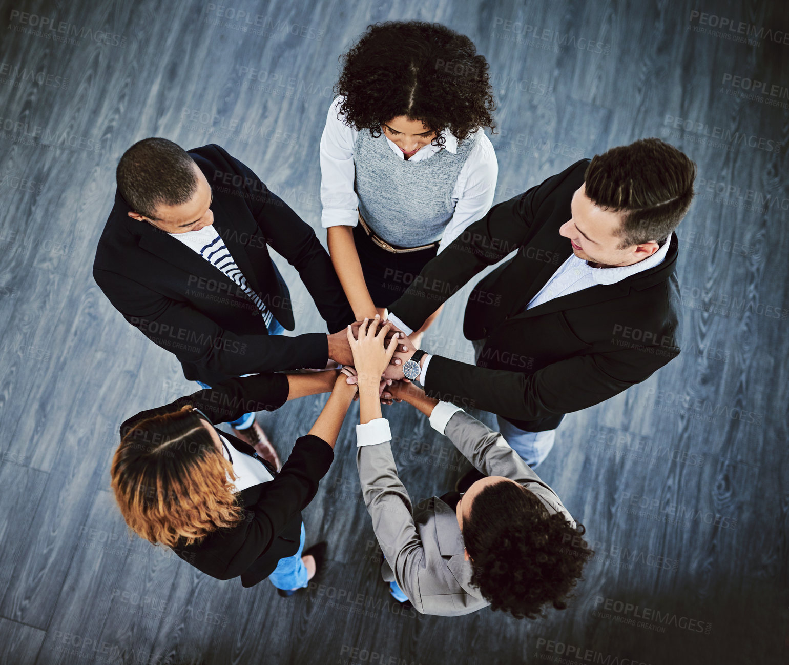 Buy stock photo High angle shot of a group of businesspeople joining their hands together in a huddle