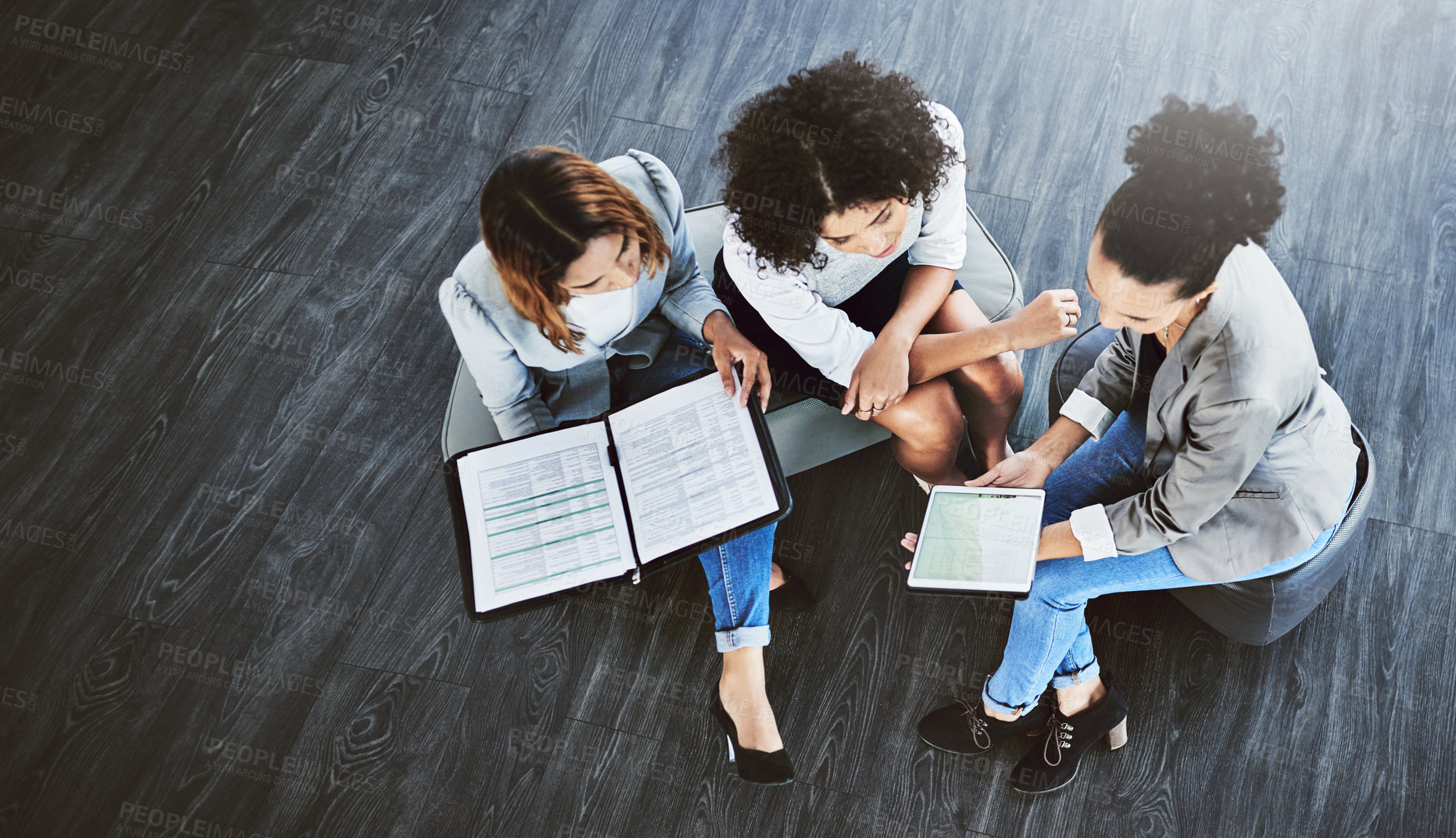 Buy stock photo High angle shot of a group of businesswomen having a discussion in an office