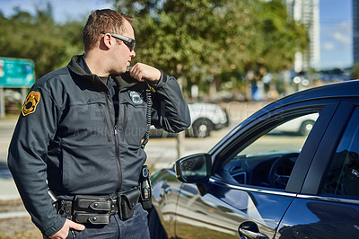Buy stock photo Police, radio and security with a man officer outdoor on patrol while talking to headquarters for a situation report. Law, safety and communication with a policeman on the street for justice 