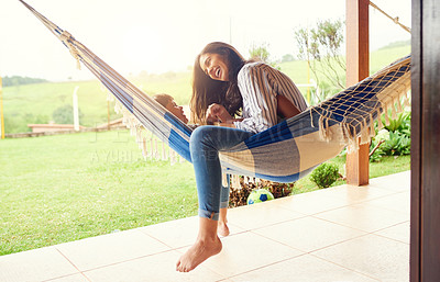 Buy stock photo Full length shot of an attractive young woman and her son bonding outside on the hammock