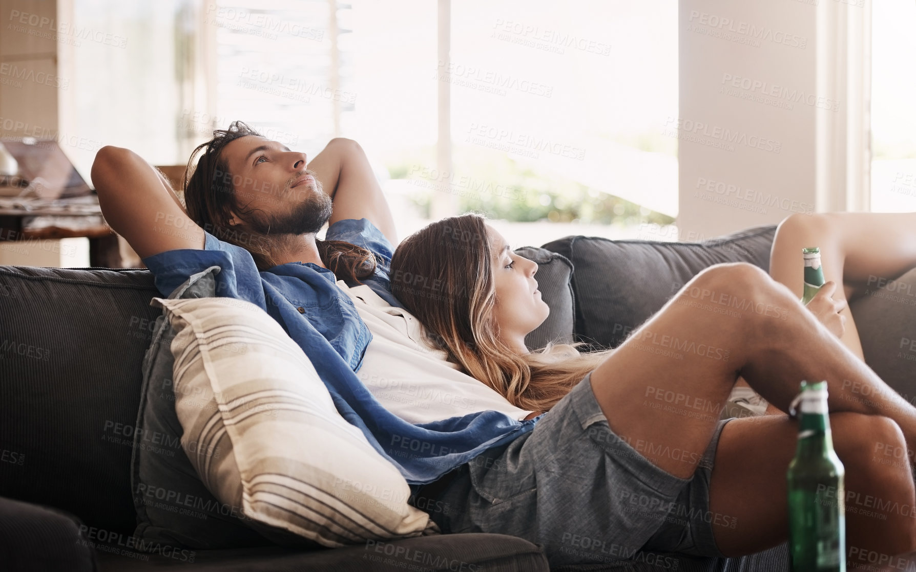 Buy stock photo Cropped shot of an affectionate young couple chilling on the sofa together at home