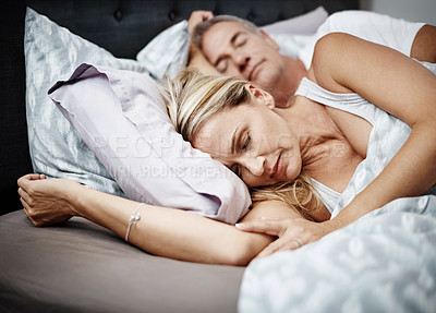 Buy stock photo Cropped shot of a mature couple sleeping in their bed