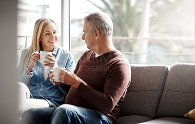 Buy stock photo Shot of a mature couple enjoying a relaxing coffee break on the sofa together at home