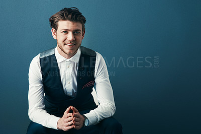 Buy stock photo Studio shot of a handsome young businessman posing against a blue background