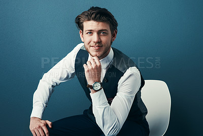 Buy stock photo Studio shot of a handsome young businessman looking thoughtful against a blue background