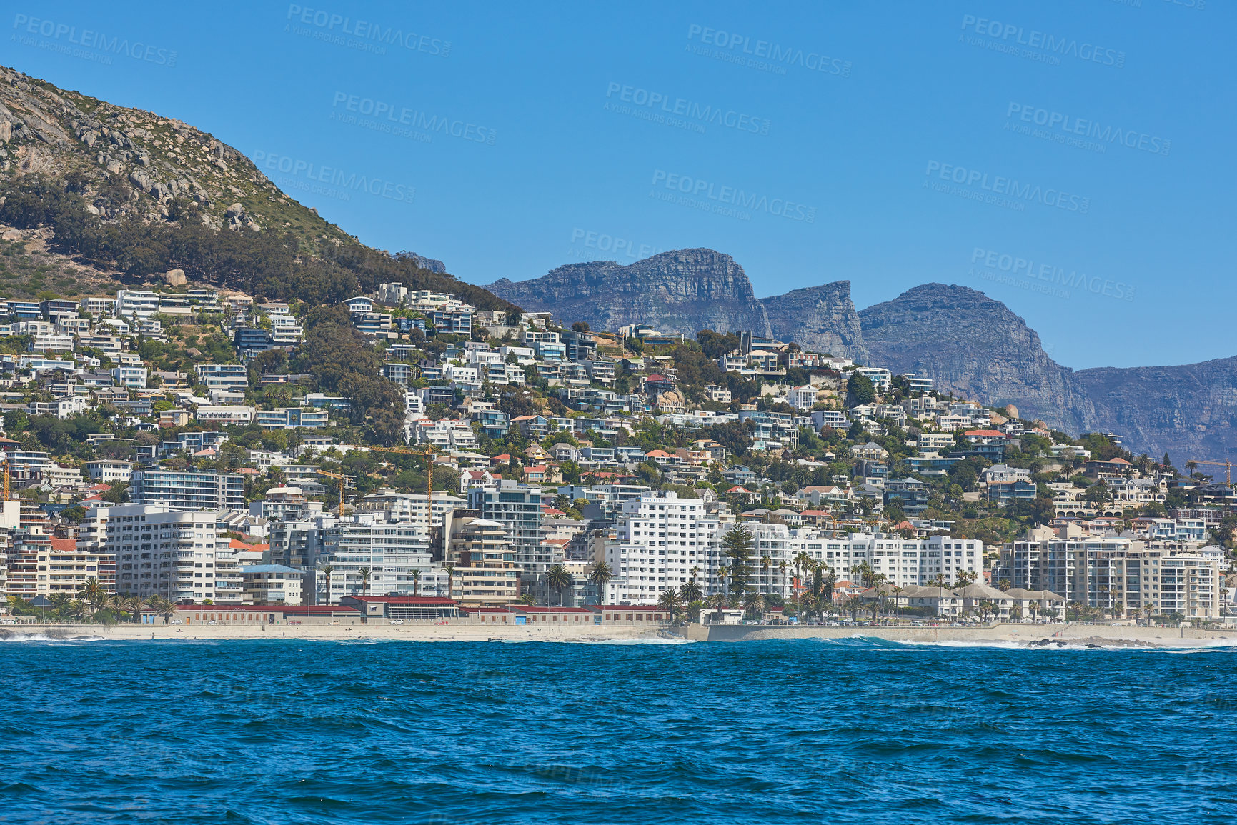 Buy stock photo Panorama seascape with clouds, blue sky, and fancy hotel apartment buildings in the background. Sea Point with the Twelve Apostles and Table Mountain National Park in Cape Town, South Africa