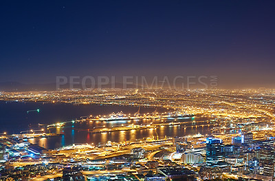 Buy stock photo Aerial view of the night cityscape of Cape Town, South Africa. Wide angle of beautiful scenic view city lights in the evening. High angle view from the signal hill in the darkness in a coastal town.