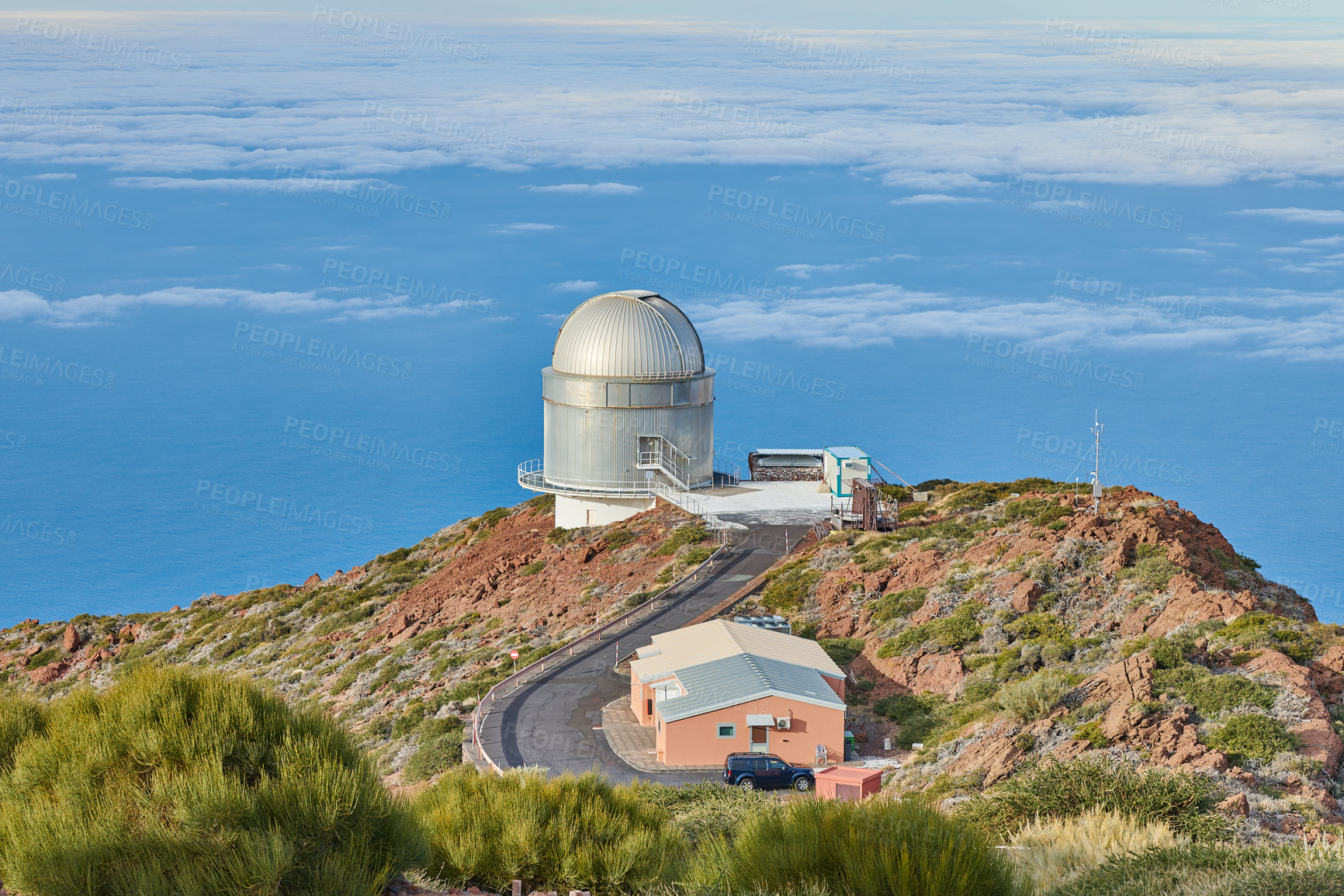 Buy stock photo Roque de los Muchachos Observatory in La Palma. A road to an astronomical observatory with blue sky and copy space. Telescope surrounded by greenery and located on an island at the edge of a cliff. 