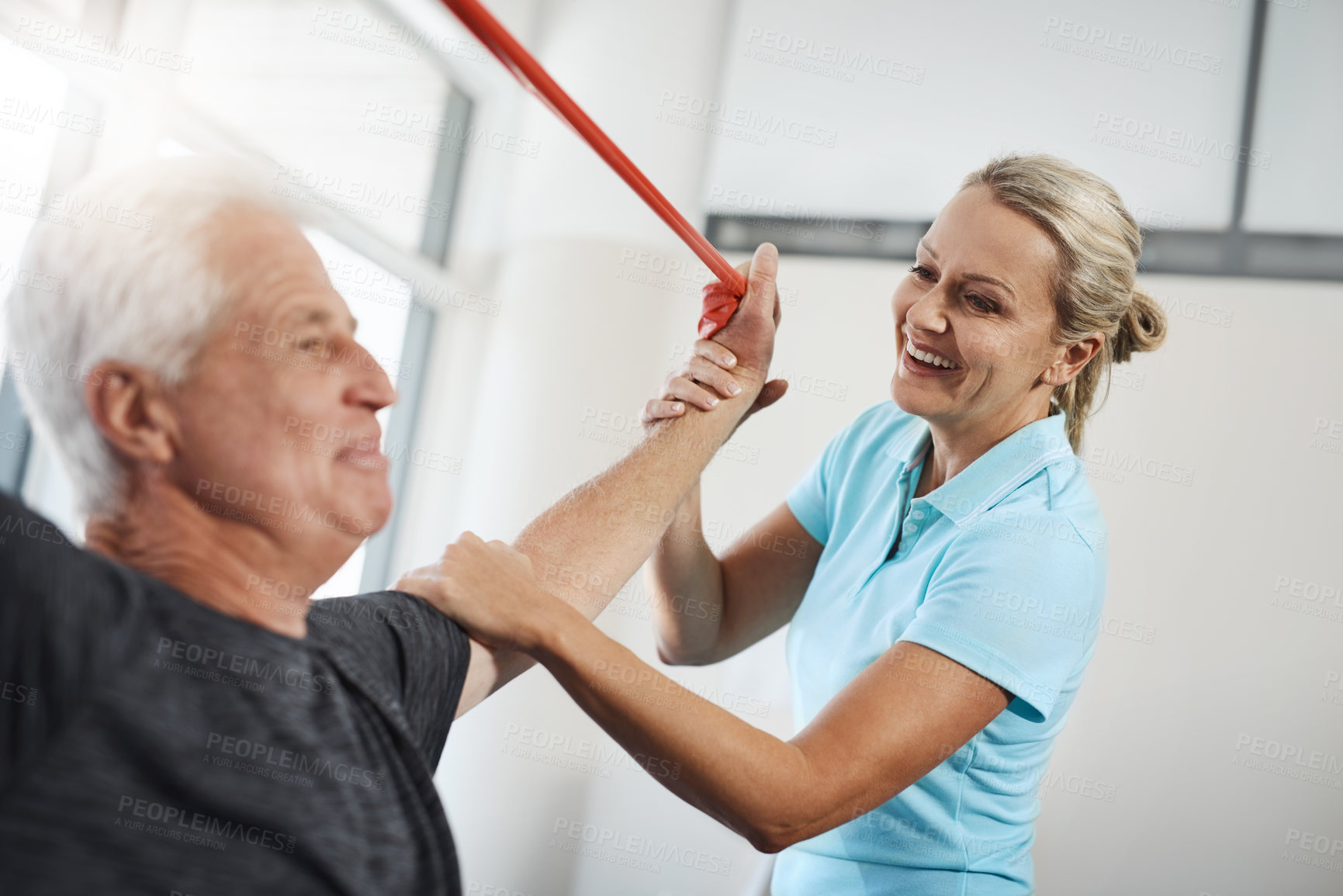 Buy stock photo Physical therapy, resistance band and senior patient with medical support, help and happy for healthcare services. People, doctor or chiropractor with elderly client, stretching and shoulder strength