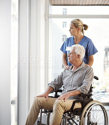 Buy stock photo Cropped shot of a mature female nurse and her senior male wheelchair-bound patient in the hospital