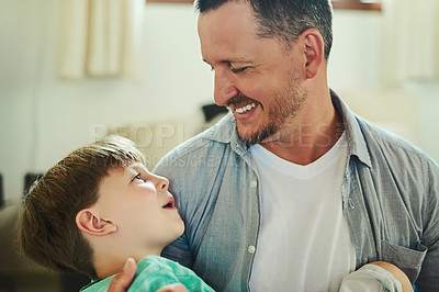 Buy stock photo Cropped shot of a handsome young father spending time with his adorable little son in the living room at home