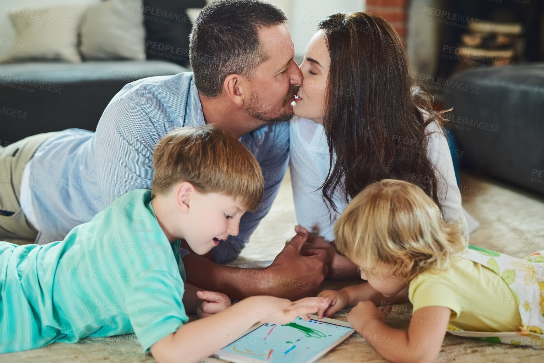 Buy stock photo Parents, kiss or siblings playing with tablet or love for bonding, family home and child development. Mom, father or children streaming online together with technology, kids or games for boy and girl