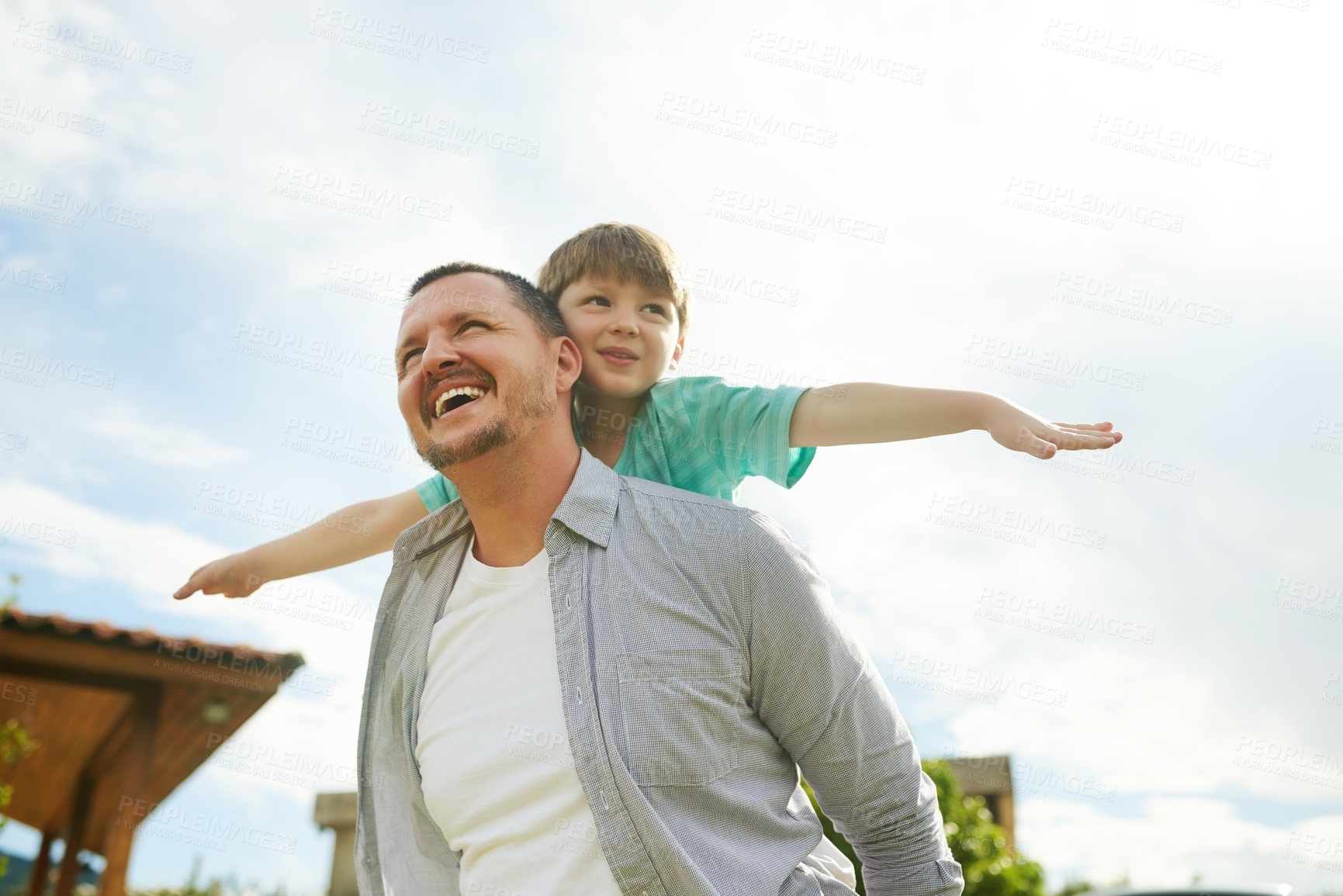 Buy stock photo Cropped shot of a young handsome father giving his adorable little son a piggyback ride in the backyard at home