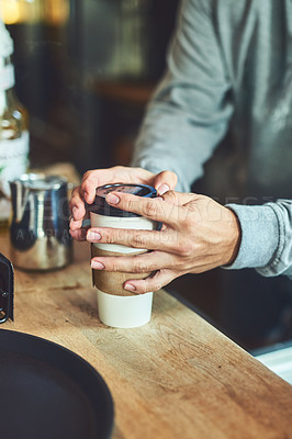 Buy stock photo Closeup shot of an unrecognizable barista closing a cup of freshly brewed coffee in a cafe
