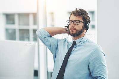 Buy stock photo Shot of a young man experiencing stress while working in a call center