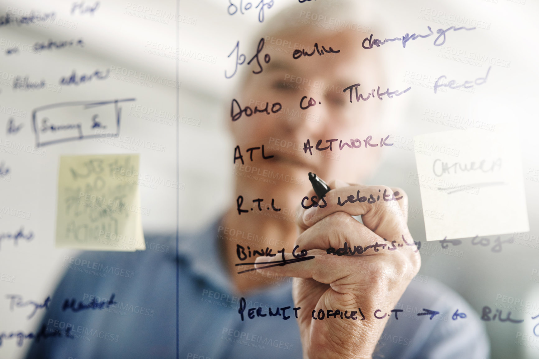 Buy stock photo Cropped shot of a senior businessman writing down ideas with a pen marker on a glass wall in the office