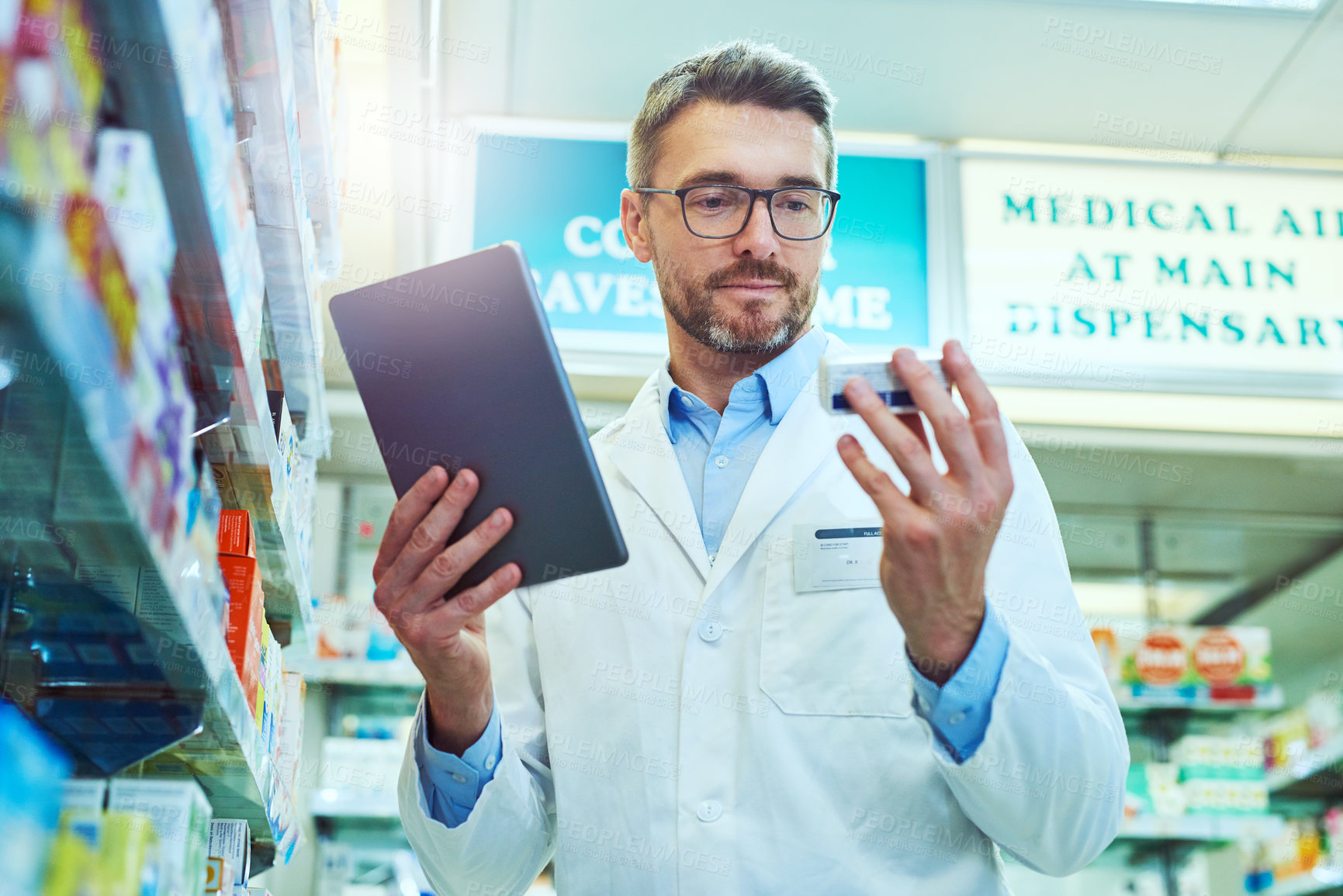 Buy stock photo Man, pharmacist and checking box with tablet for prescription, side effects or symptoms at pharmacy. Mature male person or medical employee with technology for inventory, stock or pharmaceuticals