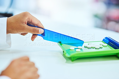 Buy stock photo Cropped shot of an unrecognizable female pharmacist separating medication in the pharmacy