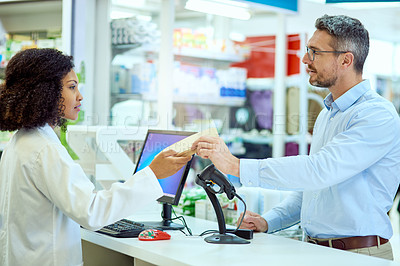 Buy stock photo Cropped shot of an attractive young female pharmacist helping a male customer in the pharmacy