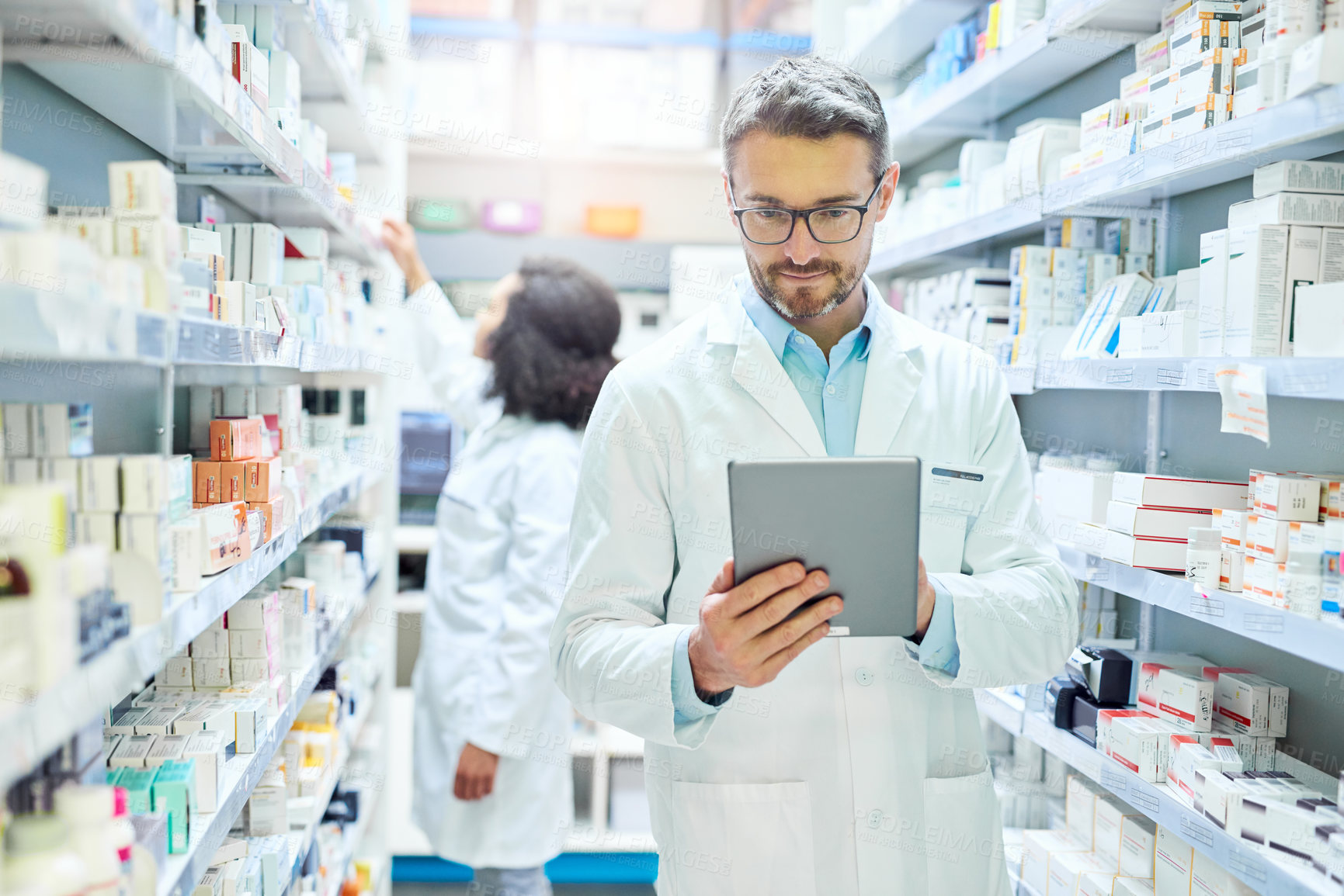 Buy stock photo Man, pharmacy and tablet with reading for inventory, stock or drugs for order from supplier. Pharmacist, people and notes on touchscreen for sales stats, product or pills on healthcare app at shop