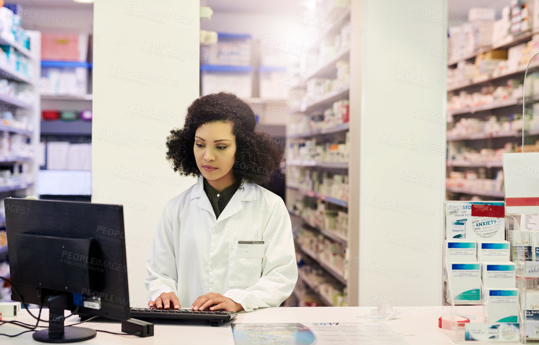 Buy stock photo Cropped shot of a pharmacist working on a computer in a pharmacy