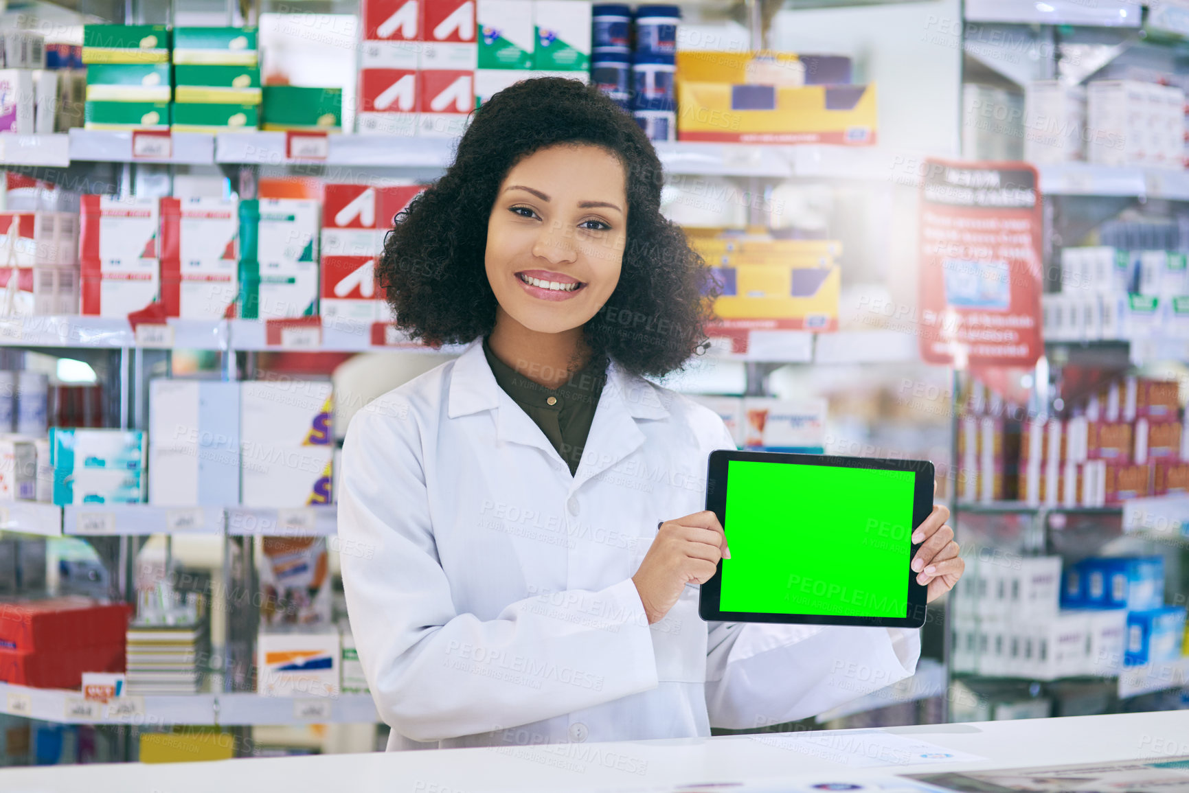 Buy stock photo Shot of a pharmacist holding up a tablet with a chromakey screen
