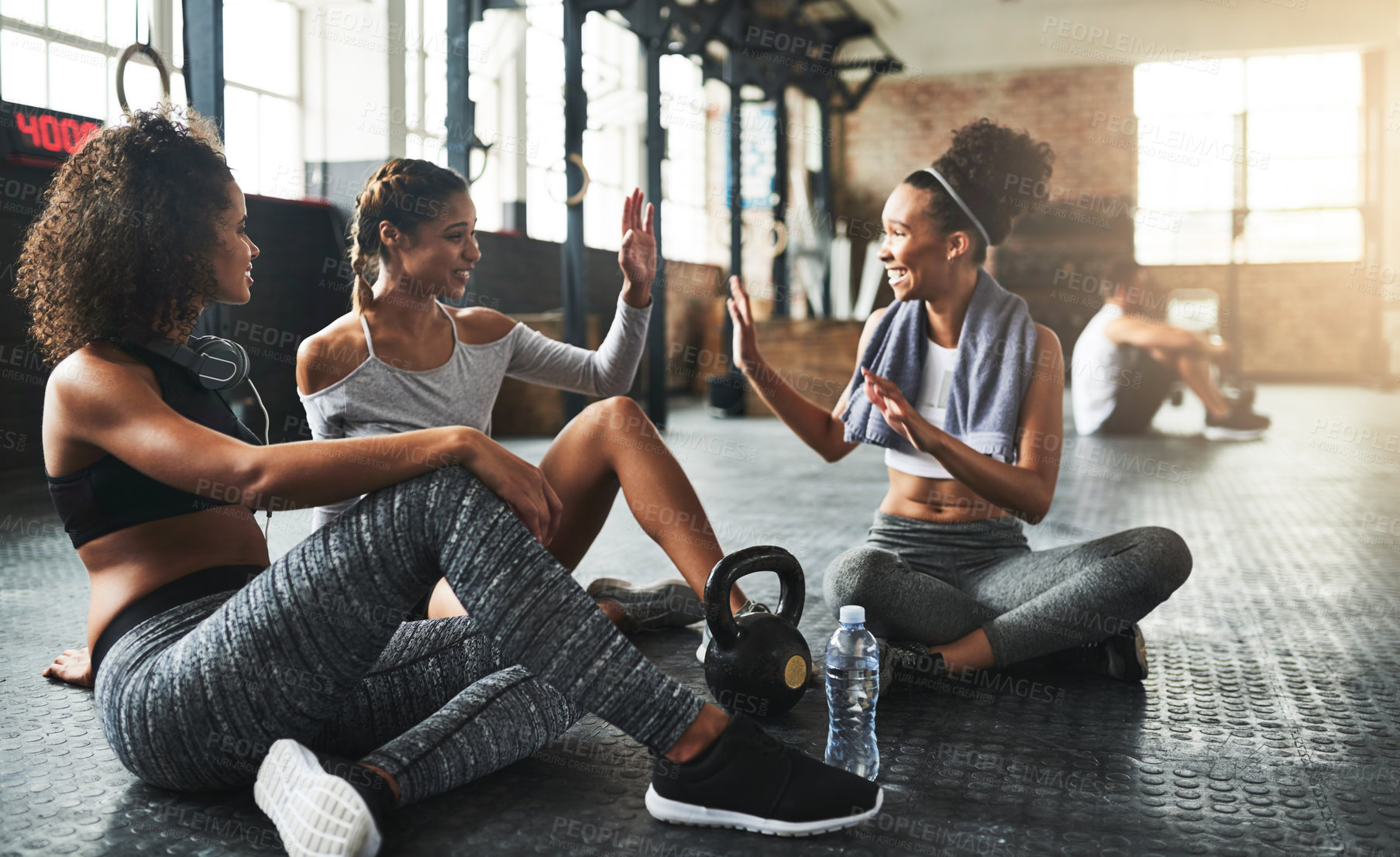 Buy stock photo Shot of young women giving each other a high five while taking a break at the gym