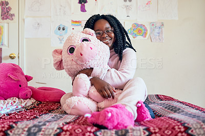 Buy stock photo Portrait of an adorable little girl holding a plush toy while sitting on her bed in her bedroom