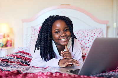 Buy stock photo Shot of an adorable little girl using a laptop while lying on her bed in her bedroom