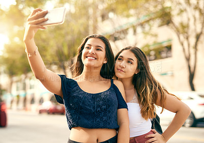 Buy stock photo Cropped shot of two best friends taking a selfie in the city