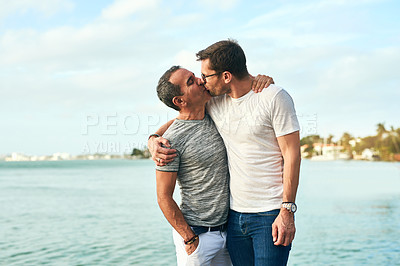 Buy stock photo Kissing, beach and hug with gay couple, love and bonding together with romance for travel. Queer people, joy and men with embrace, honeymoon and ocean with adventure, relationship and marriage