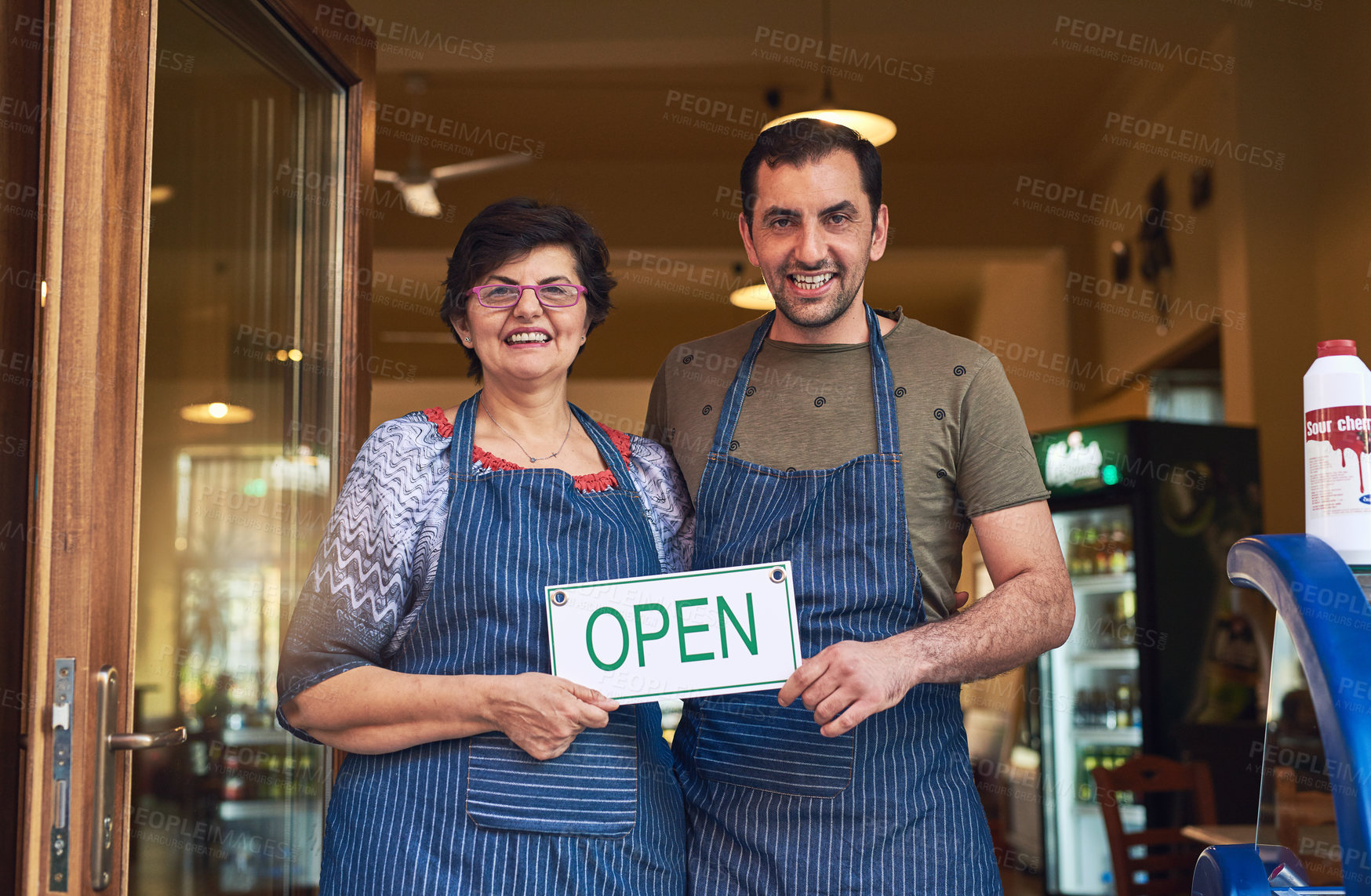 Buy stock photo Cropped portrait of a mature woman and her adult son standing in the entrance way to their family ice cream shop