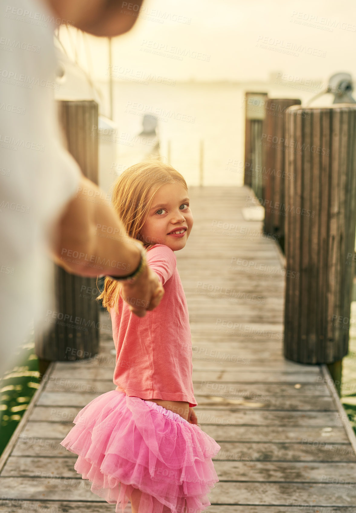 Buy stock photo Cropped shot of an adorable little girl leading her father down the pier at the beach