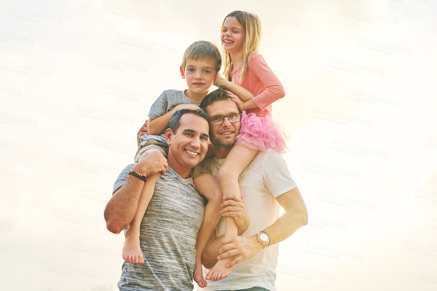 Buy stock photo Parents, children and outdoor on shoulders in portrait, family bonding and support in nature. Gay couple, security and love for kids in relationship, carrying together and play on vacation for games