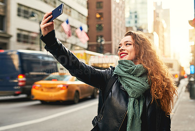 Buy stock photo Cropped shot of a young woman taking selfies while out in the city