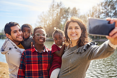 Buy stock photo Shot of a happy family taking a selfie together outdoors