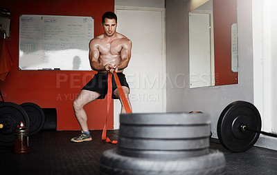 Buy stock photo Full length shot of a handsome and muscular young man pulling weights in the gym
