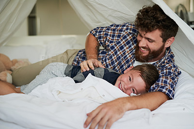 Buy stock photo Cropped portrait of an adorable little boy lying on the bed at home with his dad