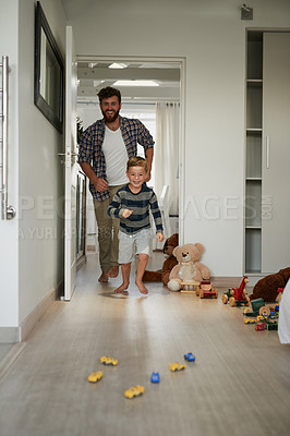 Buy stock photo Full length shot of a handsome young man chasing his son around the house