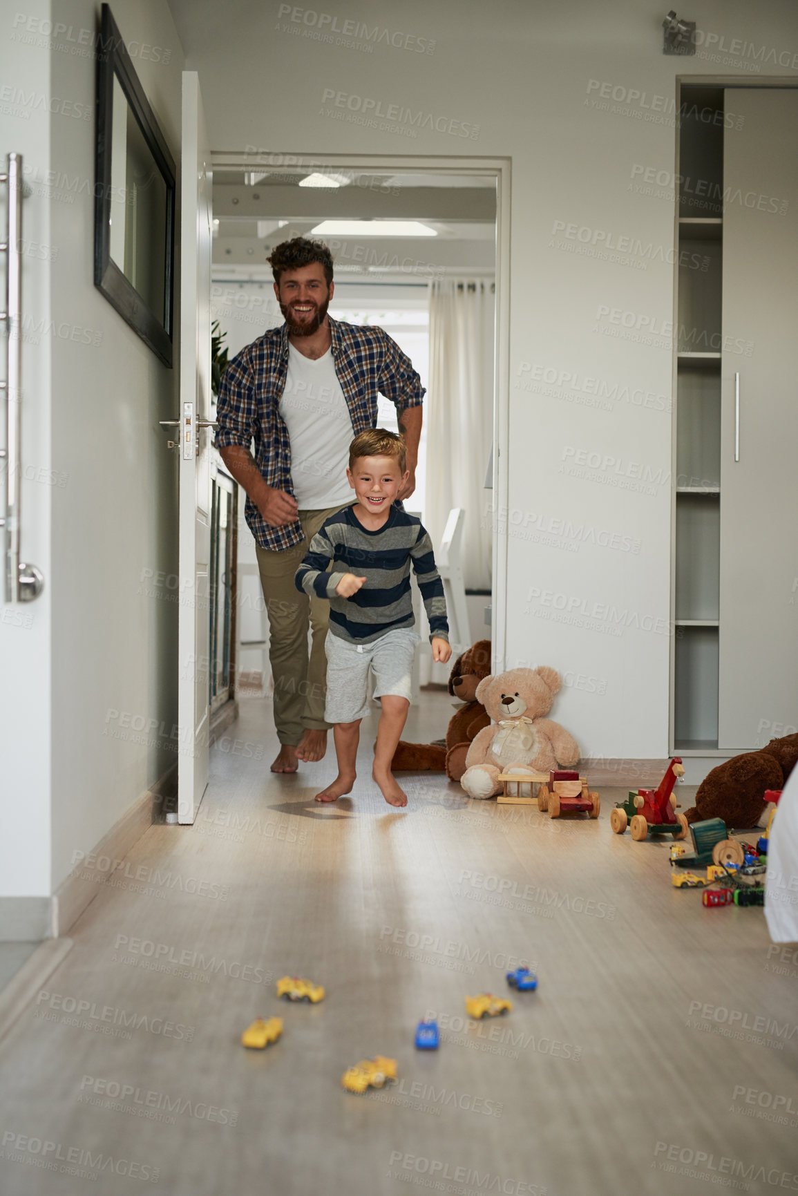 Buy stock photo Full length shot of a handsome young man chasing his son around the house