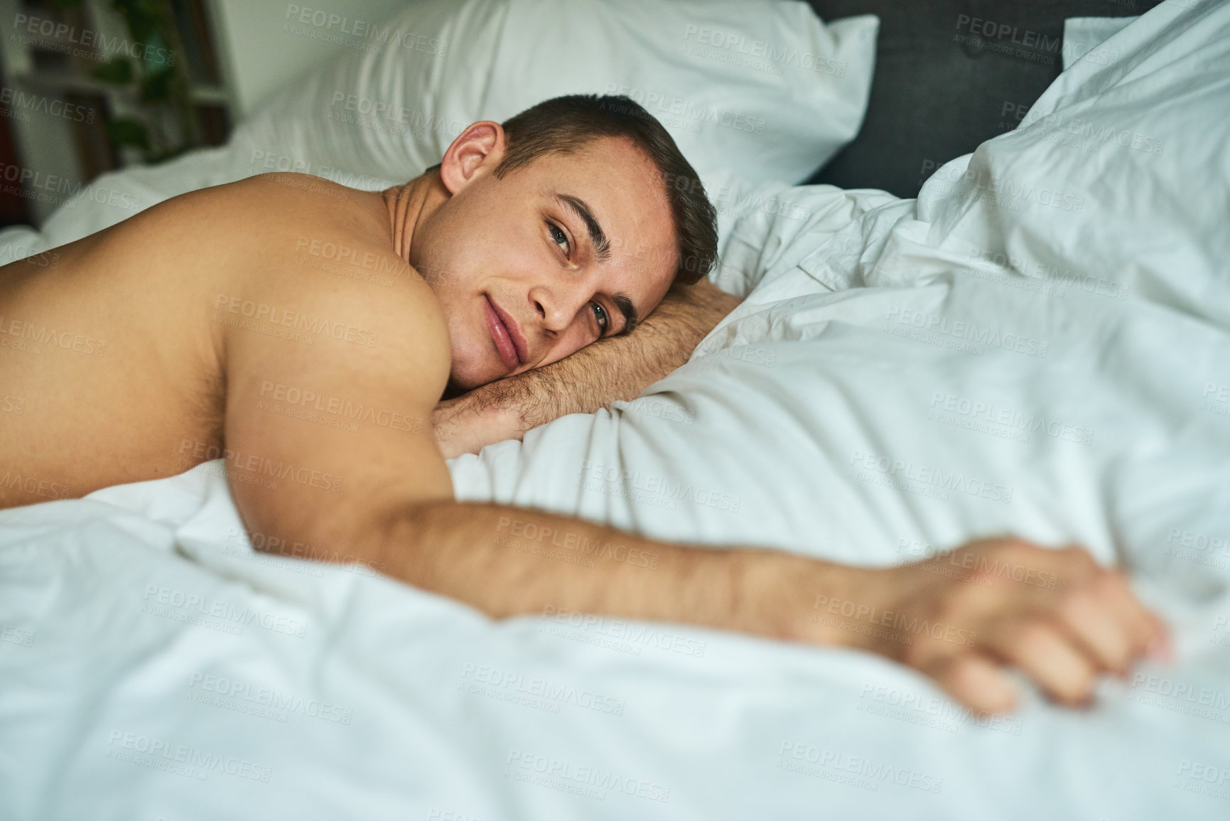 Buy stock photo Cropped shot of a young handsome man lying in bed at home