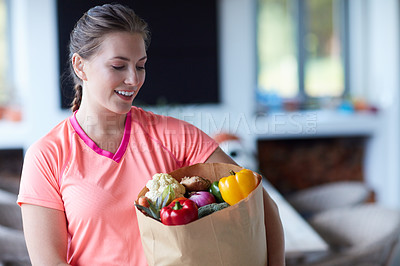 Buy stock photo Cropped shot of a young attractive woman carrying a bag of groceries at home