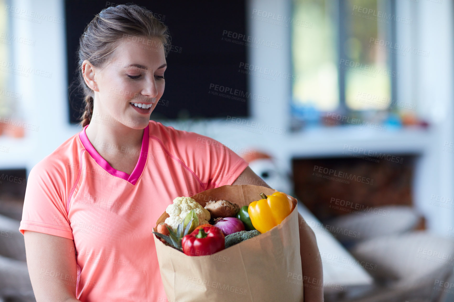 Buy stock photo Cropped shot of a young attractive woman carrying a bag of groceries at home